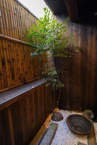 a tree in the corner of a wooden fence at Shirakabanoyado-DOUNIWA, Private House Near Osaka Castle, 白樺の宿-堂庭 in Osaka