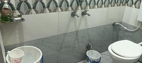 a bathroom with a toilet and two trash cans at Sheetal palce hotel in Ujjain