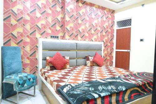 a bedroom with a large bed and a chair at Sheetal palce hotel in Ujjain