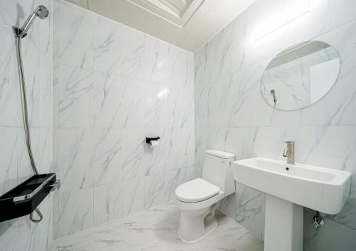 a white bathroom with a toilet and a sink at Hasen Hotel in Siheung