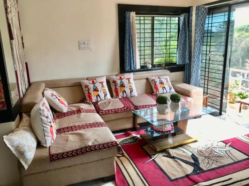 a living room with a couch and a glass table at Vishnoo Stays Lush Green Room in Atal Nagar in Nawāgaon
