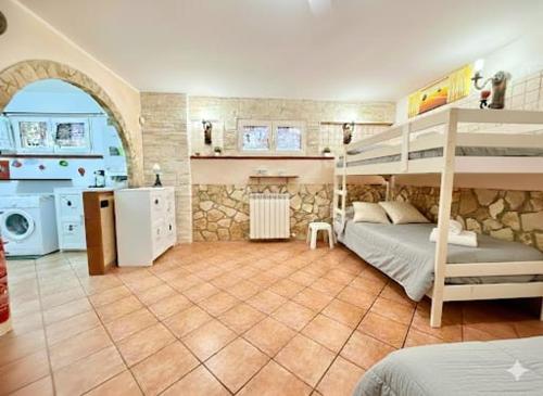 a bedroom with a bunk bed and a kitchen at OPEN SPACE Littoria in Latina