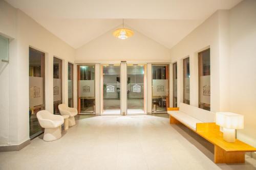 a room with a hallway with a bench and tables at Hotel Zeus in Mérida