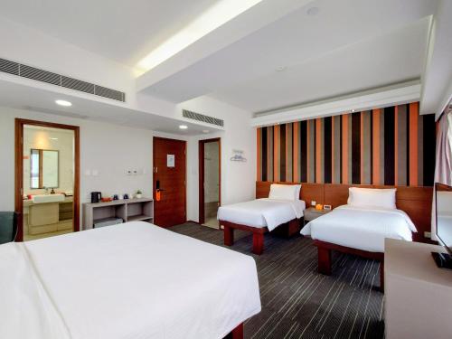 a hotel room with two beds and a bathroom at Le Prabelle Hotel in Hong Kong