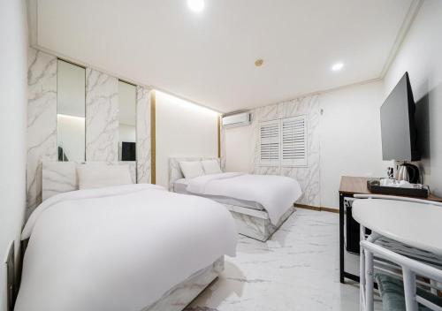 a hotel room with two beds and a sink at Hasen Hotel in Siheung