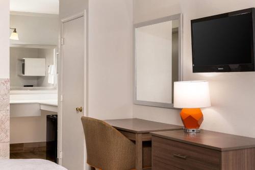 a room with a desk with a lamp and a mirror at Quality Inn South Hill I-85 in South Hill