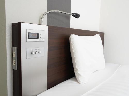 a bed with a pillow and a lamp on it at Comfort Hotel Tokyo Kanda in Tokyo