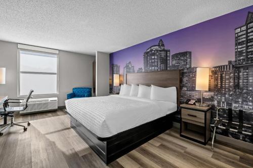 a hotel room with a bed and a city at Clarion Pointe I-85 High Point - Archdale in Westwood