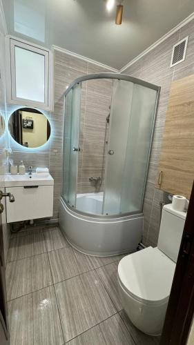 a bathroom with a shower and a toilet and a sink at Апартаменти GREEN центр вулиця Руська in Ternopil
