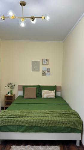 a bedroom with a green bed in a room at Апартаменти GREEN центр вулиця Руська in Ternopil