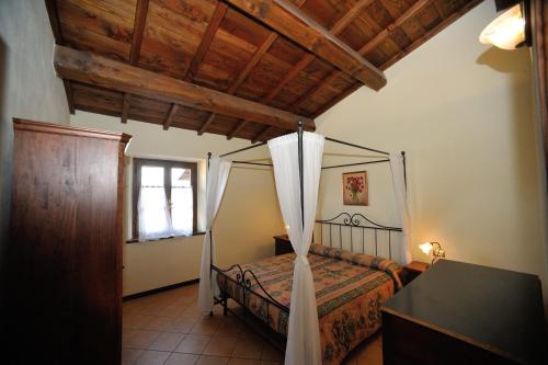 a bedroom with a canopy bed and a window at Agriturismo Polla in Camporgiano