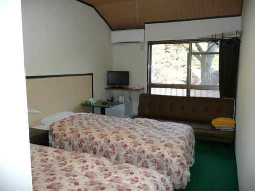 a hotel room with two beds and a window at Hotel Famitic Myojin in Nikko