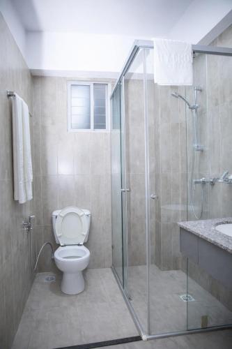 a bathroom with a toilet and a glass shower at City Crown Hotel in Dar es Salaam