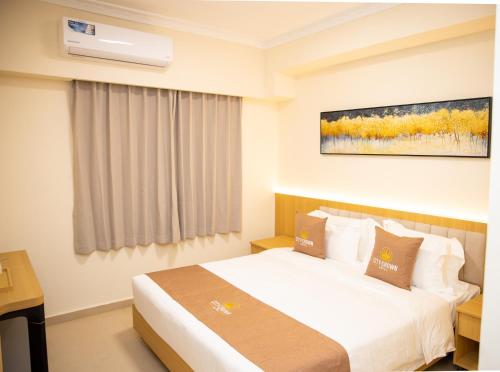 a hotel room with a bed and a air conditioner at City Crown Hotel in Dar es Salaam