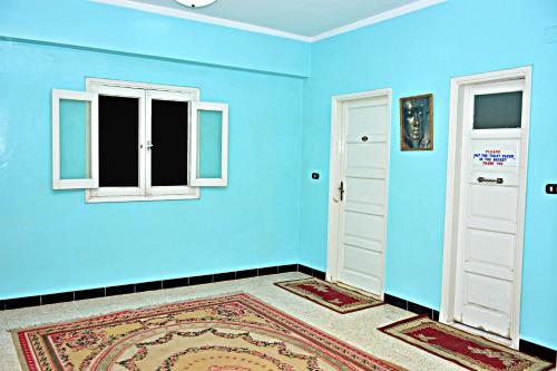 a blue room with two windows and a door at Fontana Luxor Hostel in Luxor