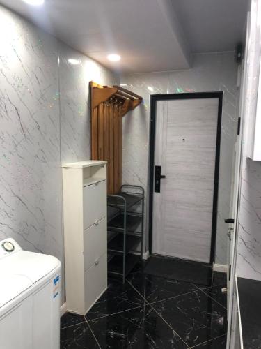 a bathroom with a shower and a sink and a door at Mini apartment in Central UB in Ulaanbaatar