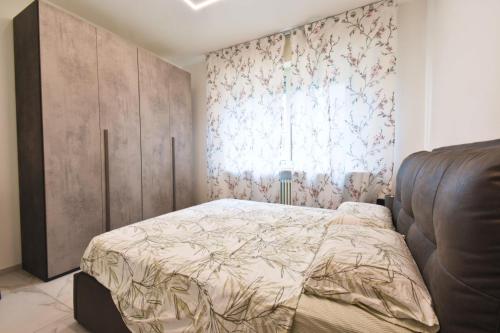a bedroom with a bed and a large window at Appartamento Delfino in Rimini