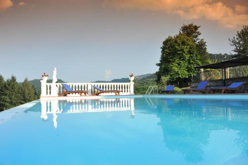 a swimming pool with two chairs and a house at Agriturismo Polla in Camporgiano
