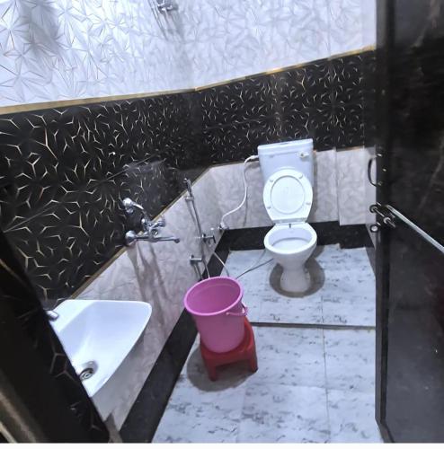 a bathroom with a toilet and a sink and a bucket at Sri Ram Shankar-Saryu Ghat in Ayodhya