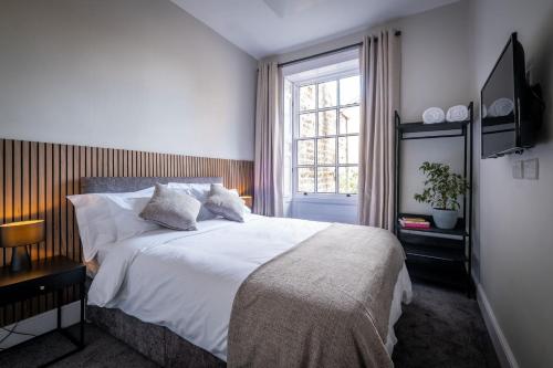 a bedroom with a white bed and a window at Dalton Sq Apartments in Lancaster