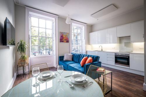 a living room with a blue couch and a table at Dalton Sq Apartments in Lancaster