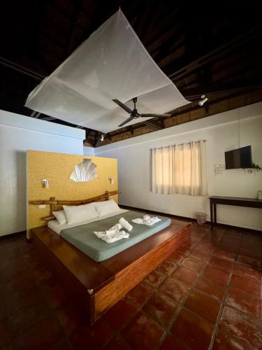 a bedroom with a large bed with a ceiling at La Natura Resort in Coron