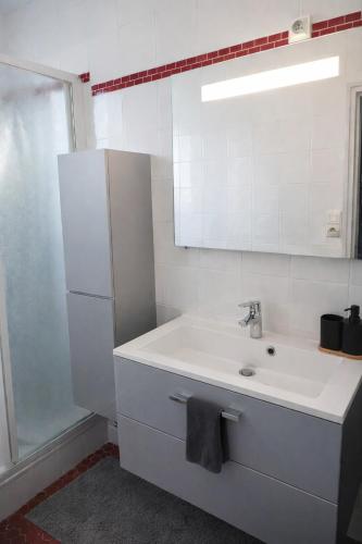 a white bathroom with a sink and a refrigerator at Séjour bercé par la Mer in Jard-sur-Mer