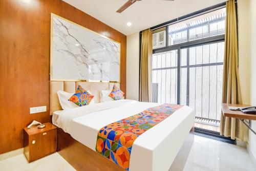 a bedroom with a bed and a large window at FabHotel Blooming Beds Pearl in Jaipur