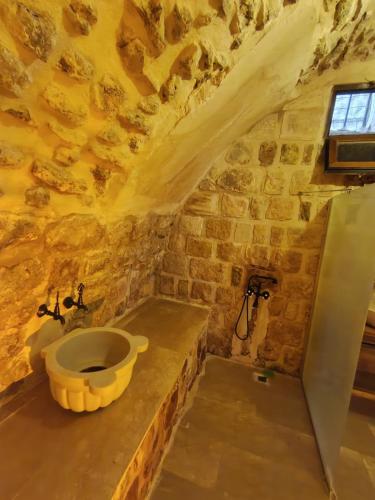 a stone walled bathroom with a sink in a room at Babussor konağı hotel in Eskiömerler