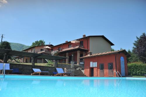 a swimming pool with chairs and a house in the background at Agriturismo Polla in Camporgiano