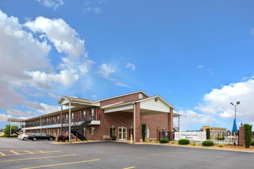 a large brick building with a parking lot at The Magnolia Hotel Searcy in Searcy