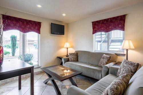 a living room with a couch and a table at The Magnolia Hotel Searcy in Searcy