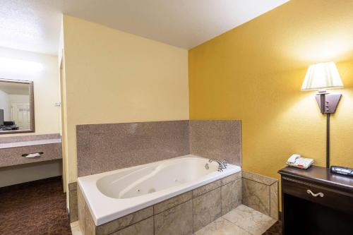 a bathroom with a bath tub in a room at The Magnolia Hotel Searcy in Searcy