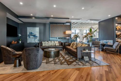 a living room with a couch and a table at Cambria Hotel Portland Downtown Old Port in Portland