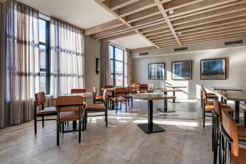 a dining room with tables and chairs and windows at Cambria Hotel Portland Downtown Old Port in Portland