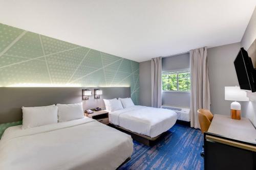 a hotel room with two beds and a television at Comfort Inn & Suites Weston - Wausau in Weston