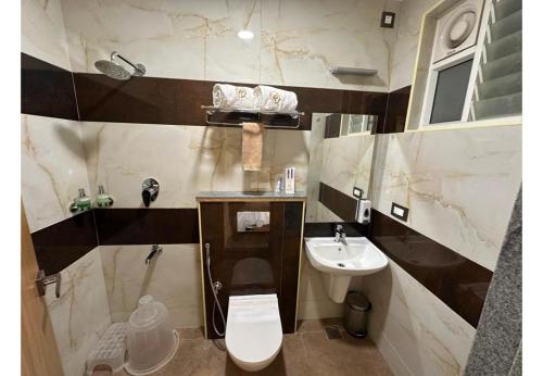 a bathroom with a toilet and a sink at The VP Residency Towerrs in Tiruttani