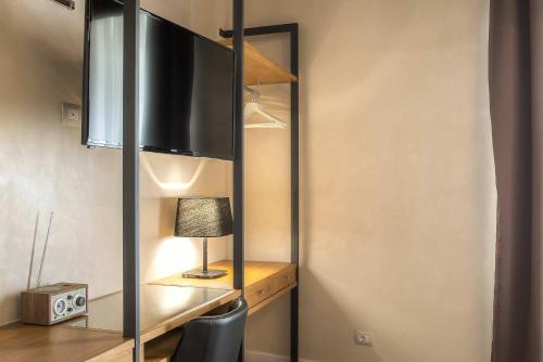 a room with a tv and a desk with a lamp at Hotel Elite in Rome