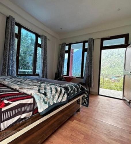 a bedroom with a bed and large windows at Majestic House , Kalga , Kalgha in Kalgha