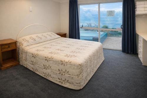 a bedroom with a bed and a view of a pool at Ascot On Fenton in Rotorua