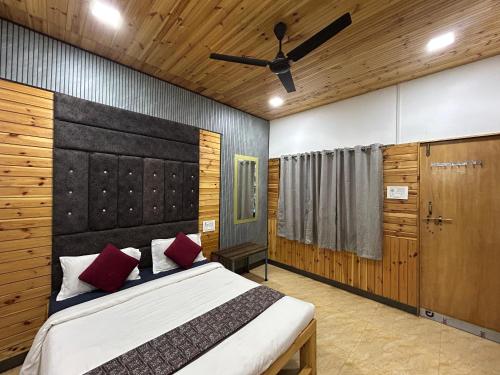 a bedroom with a large bed and a ceiling fan at Wantara resort in Diveagar