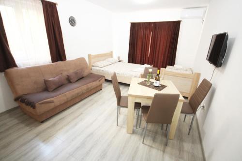 a living room with a couch and a table and a bed at Apartments KA-7 in Podgorica