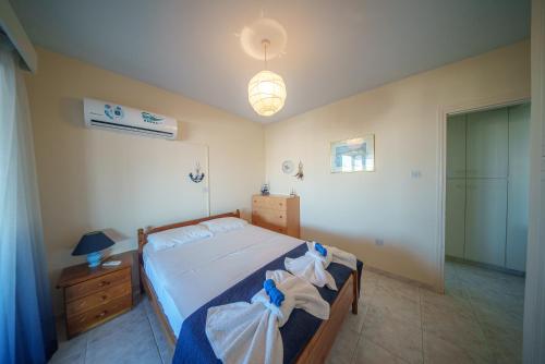a bedroom with a bed with blue and white sheets at The Blue Mile w Jacuzzi in Paralimni