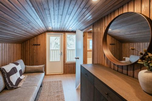 a living room with a couch and a mirror at Lapland Lakeside Villa in Ranua