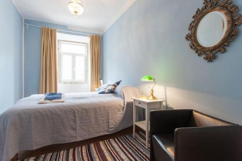 リスボンにあるArroios 100のベッドルーム1室(ベッド1台、鏡、椅子付)