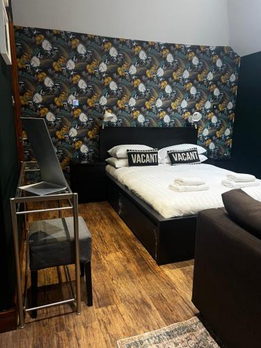 a room with a bed and a laptop on a table at Stable Yard Rooms in Richmond