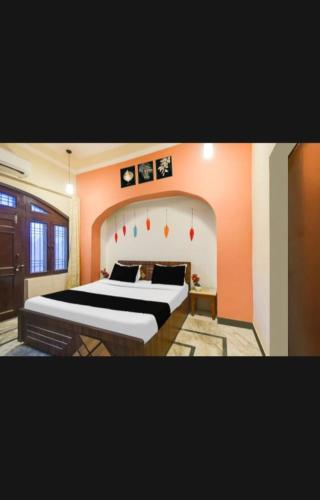 a bedroom with a large bed with an orange wall at Hotel Pink Haveli in Jaipur