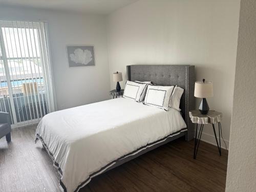 a bedroom with a large bed with white sheets and pillows at Villa Marina - AMAZING Modern, Spacious, Stylish 2 Master Suites in CENTRAL Marina Del Rey in Los Angeles