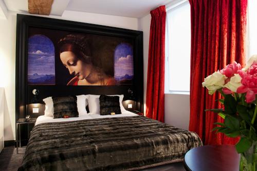 
a bedroom with a large bed and a television at Hôtel le Clos de Notre Dame in Paris
