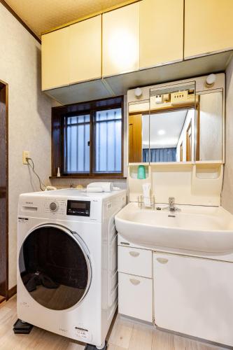 a bathroom with a washing machine and a sink at Comfort Villa Takahata in Takahate